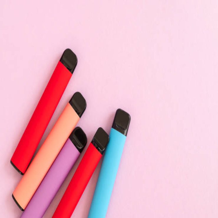 five coloured vapes on a pink background