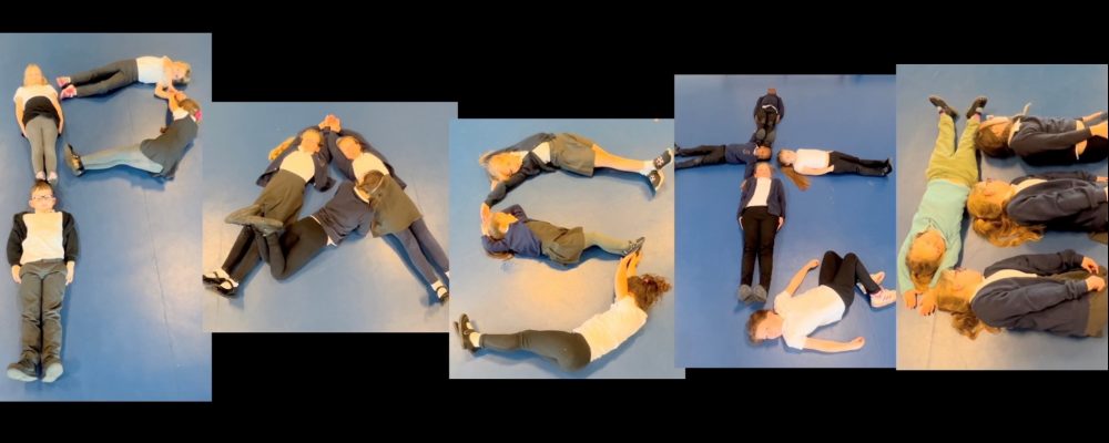 Children lying on the floor to form the letters that spell the word paste