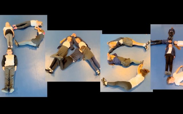 Children lying on the floor to form the letters that spell the word paste